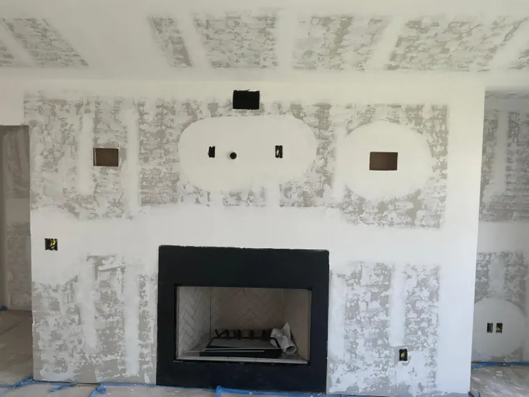 New drywall around the fireplace opening, smoothed and ready for finishing